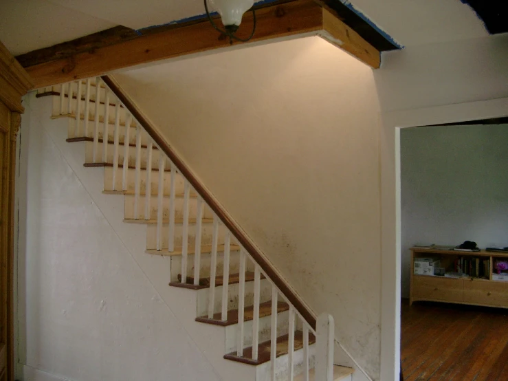 a white railing and wooden stair bannister in a room