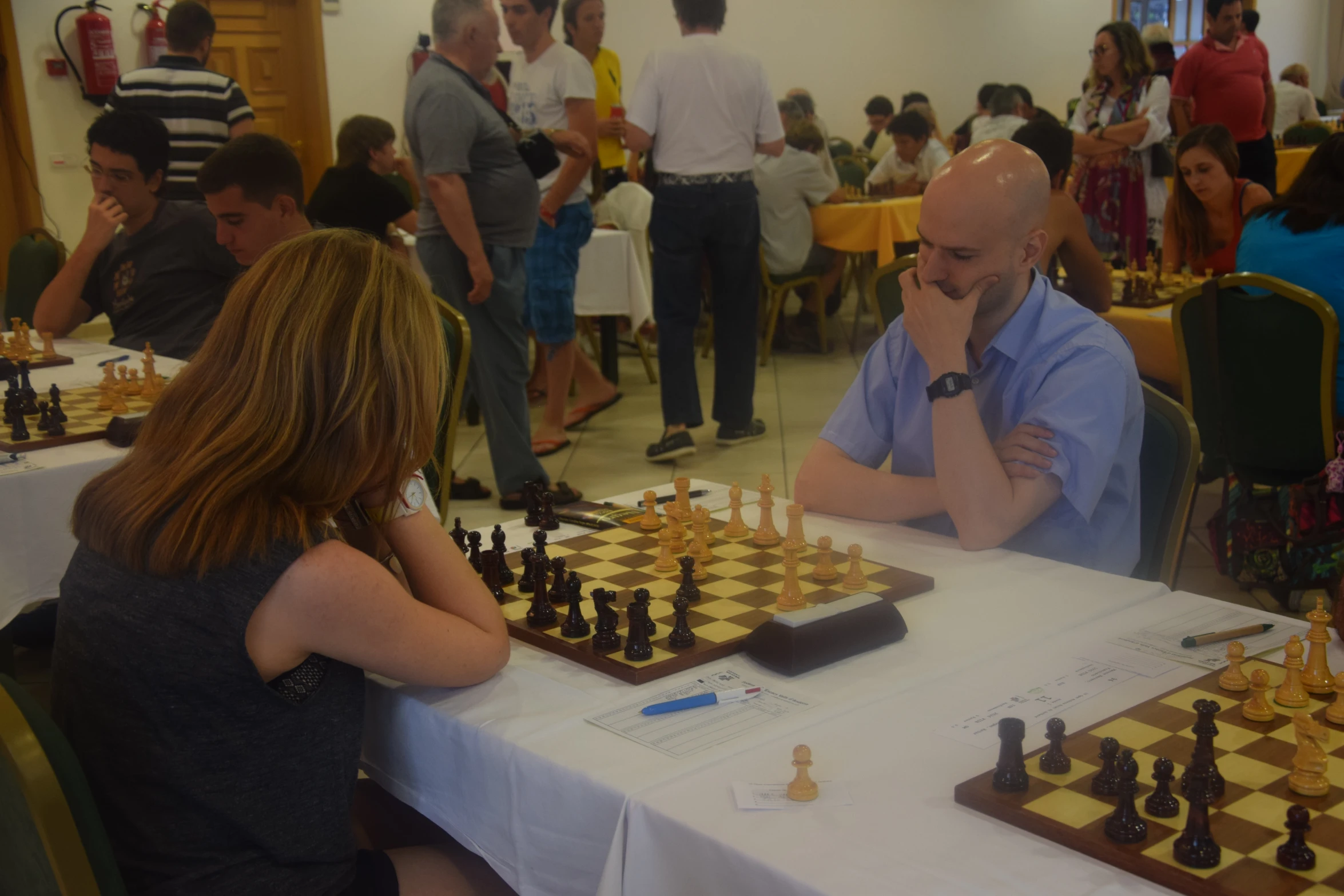 people in a room with many chess boards and pieces