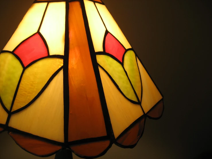 an older fashioned lamp shines brightly in the dark