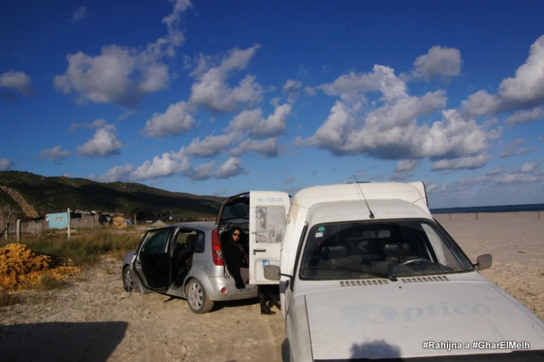 the van is parked on a dirt road