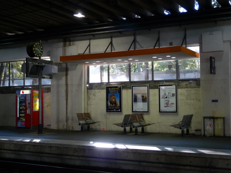 a train platform is empty with tables and benches