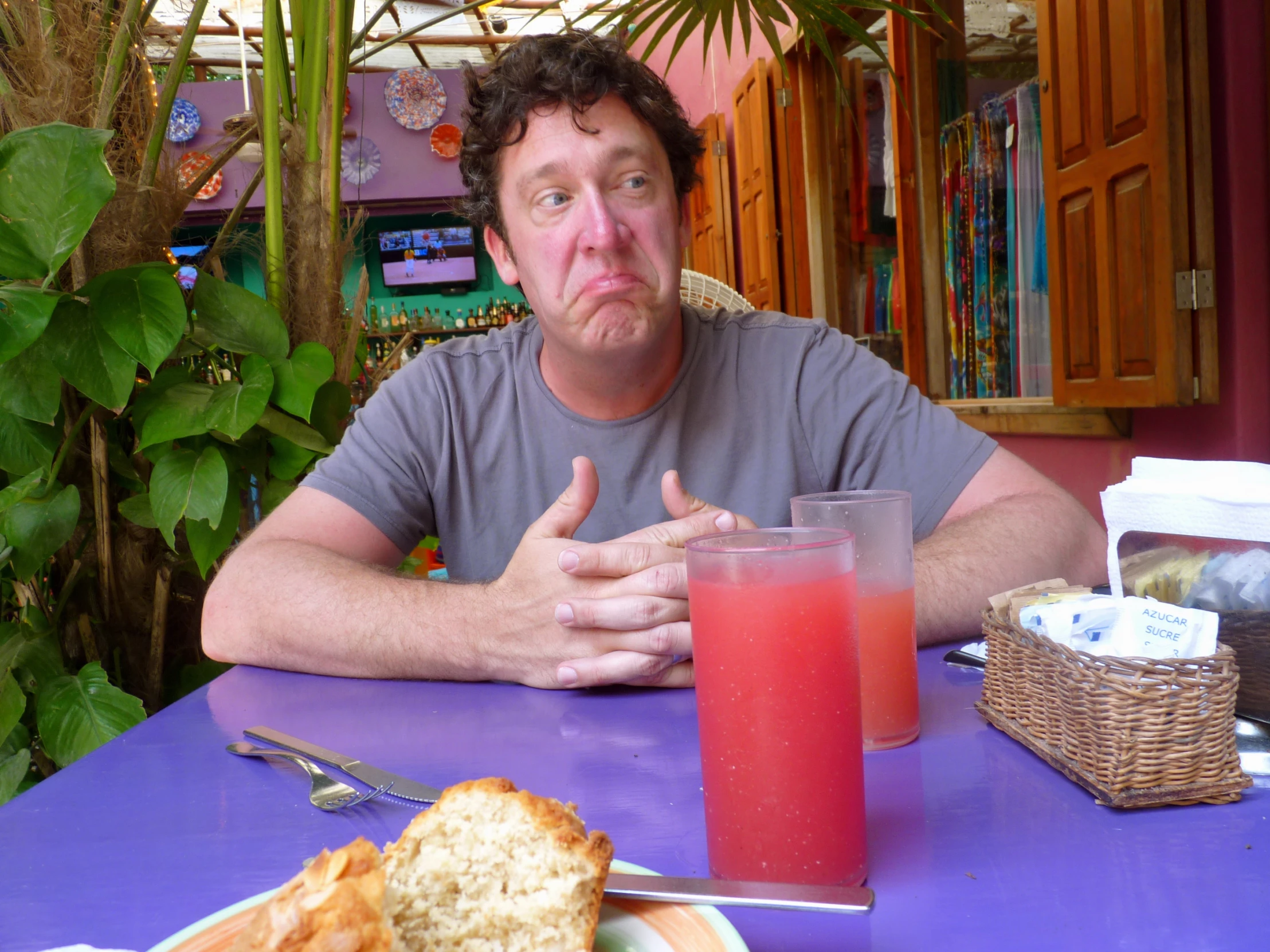 a man sitting at a table with food and drink