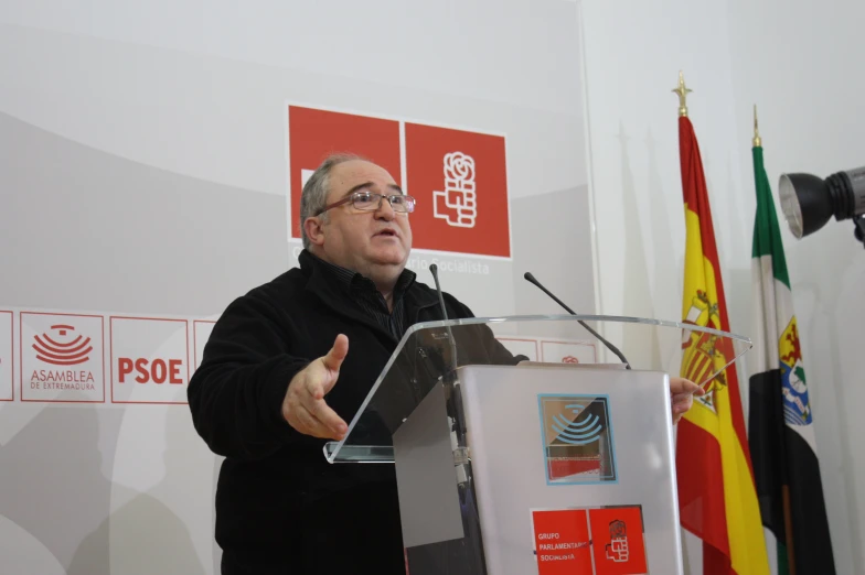 a man stands at a podium in front of flags