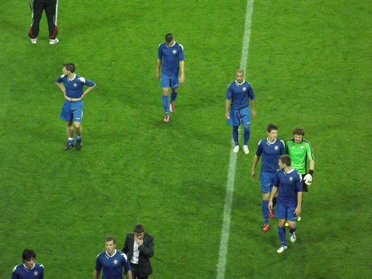 soccer players walking across the field in formation