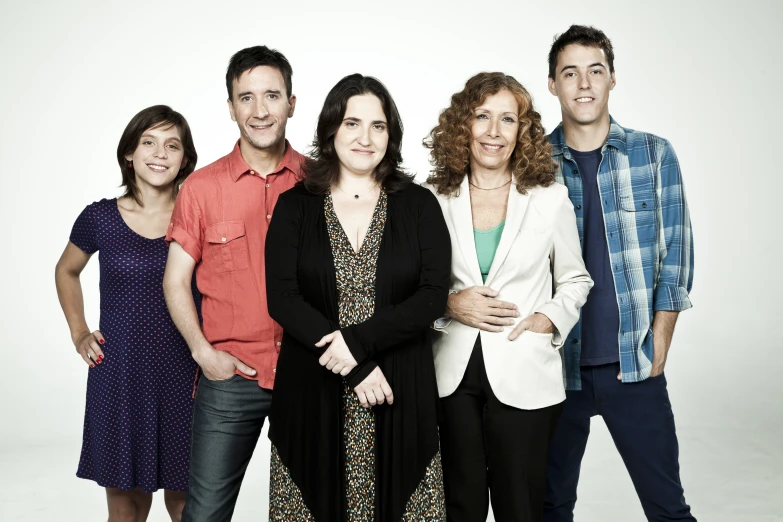 several people posing for a po in front of a white background