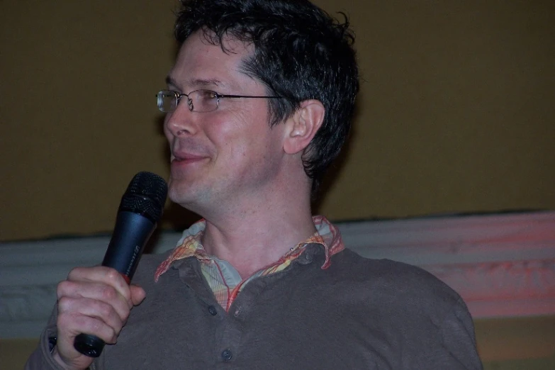 a man is holding a microphone and smiling