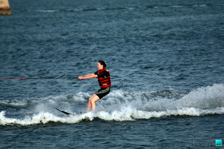 a man water skis and rides a board in the ocean