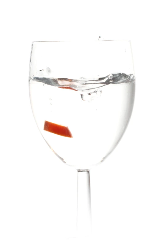 a clear glass with liquid in it has a red liquid inside