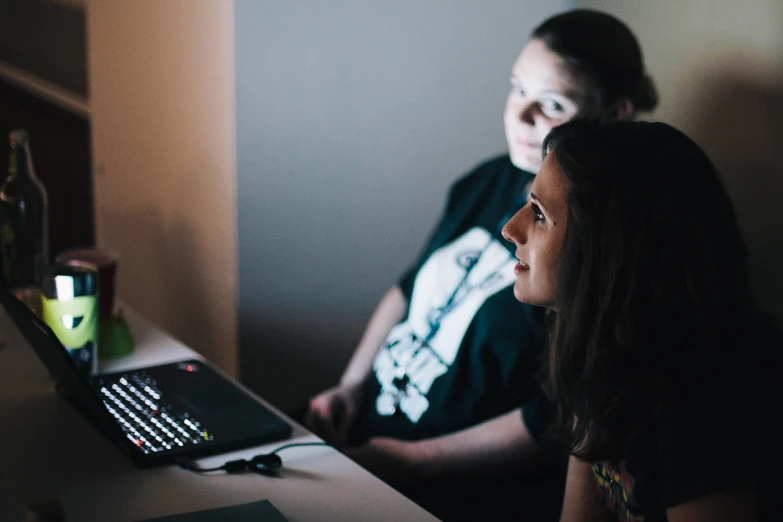 a couple of people sitting by a desk in a house