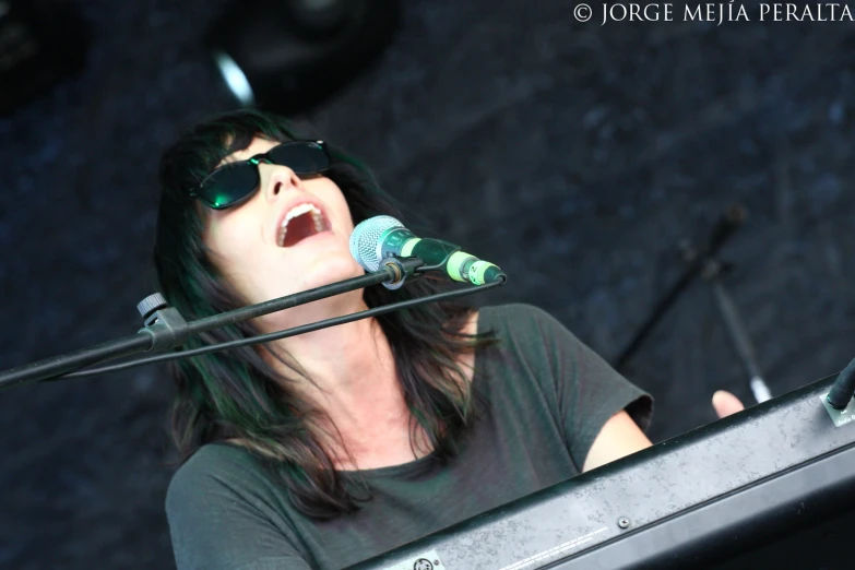 a person in sunglasses singing into a microphone