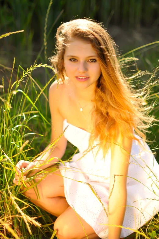 young female posing in the grass for the camera