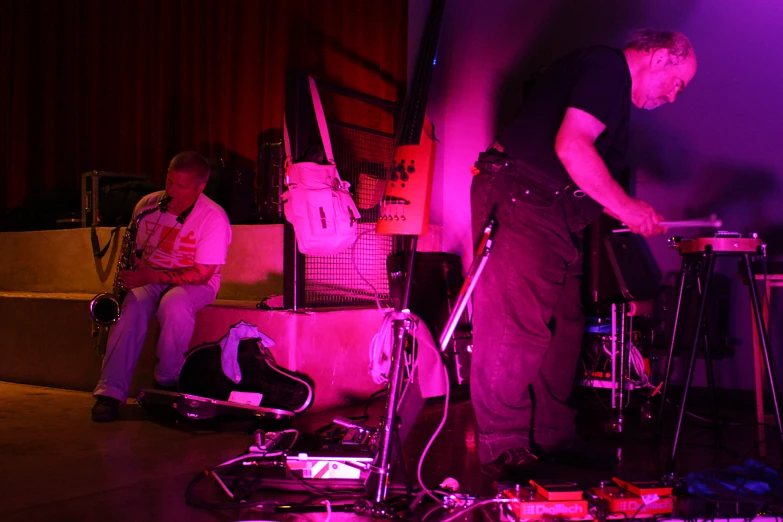 a man playing keyboards on stage with another musician