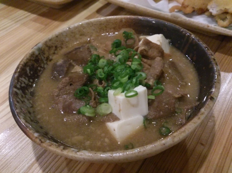 a bowl of food is on a wooden table