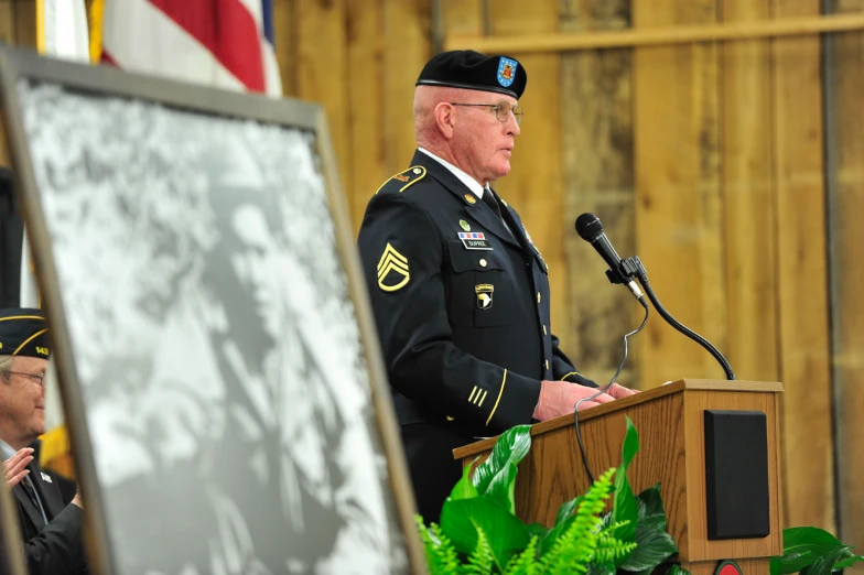 a soldier standing at a podium at the front of a house