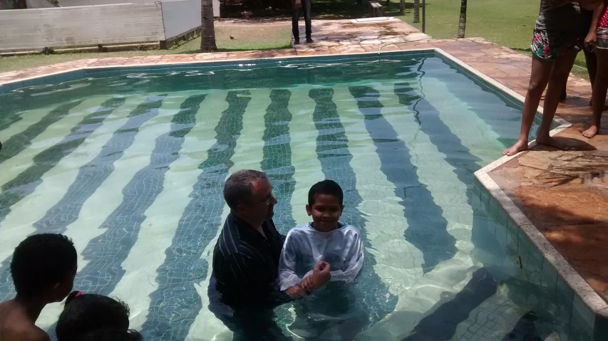 several people are in an pool near a house