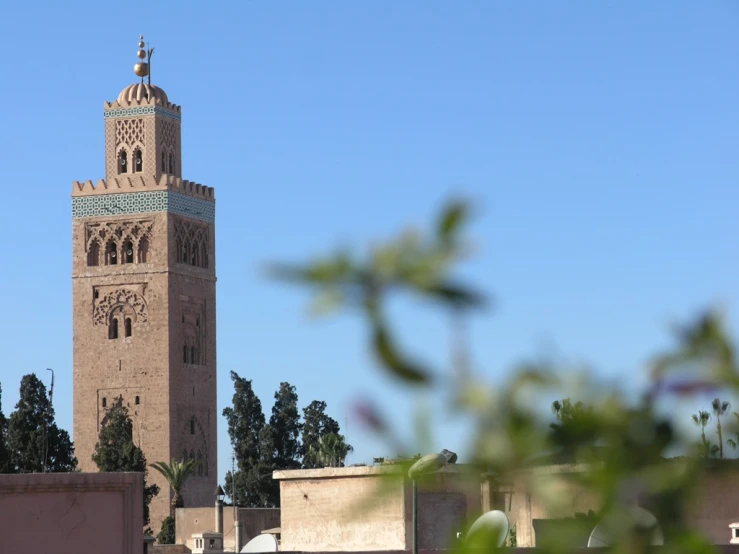 a tall clock tower towering over a city next to tall buildings