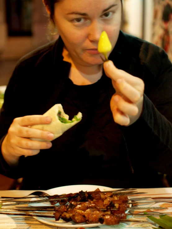 a woman is holding a piece of food with a pickle