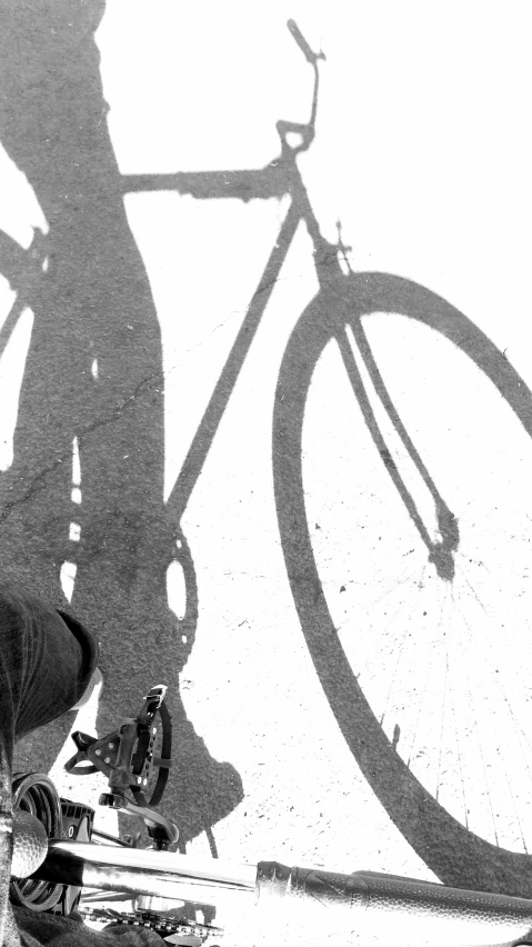 the shadow of the bike and skateboard against a wall