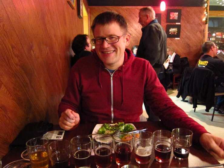 a man smiles for the camera while he eats