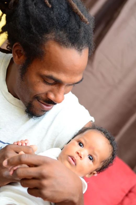 man holding young child in his arms and smiling