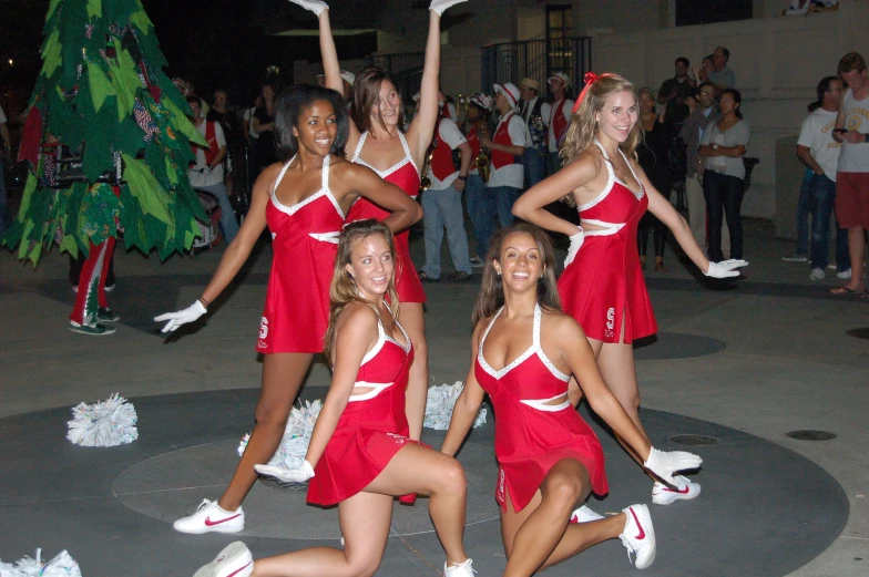 a group of girls dressed in red cheer and pose