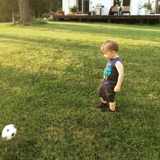 the little boy is playing with the ball