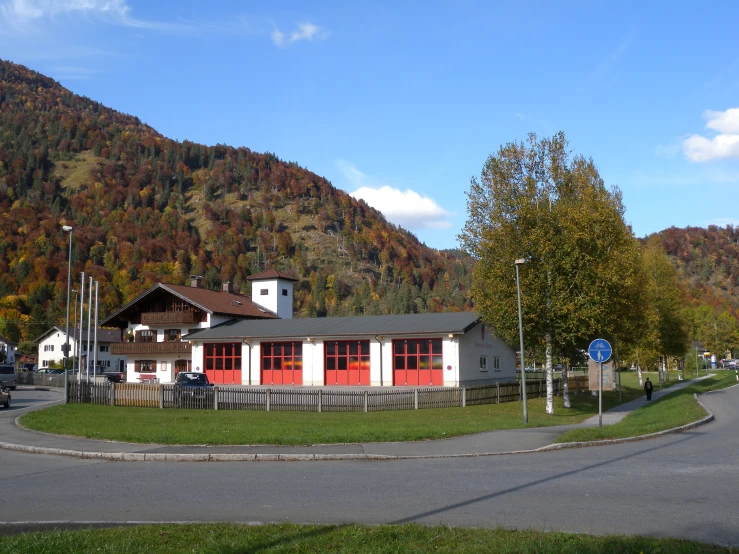 a red house near the road in front of mountains