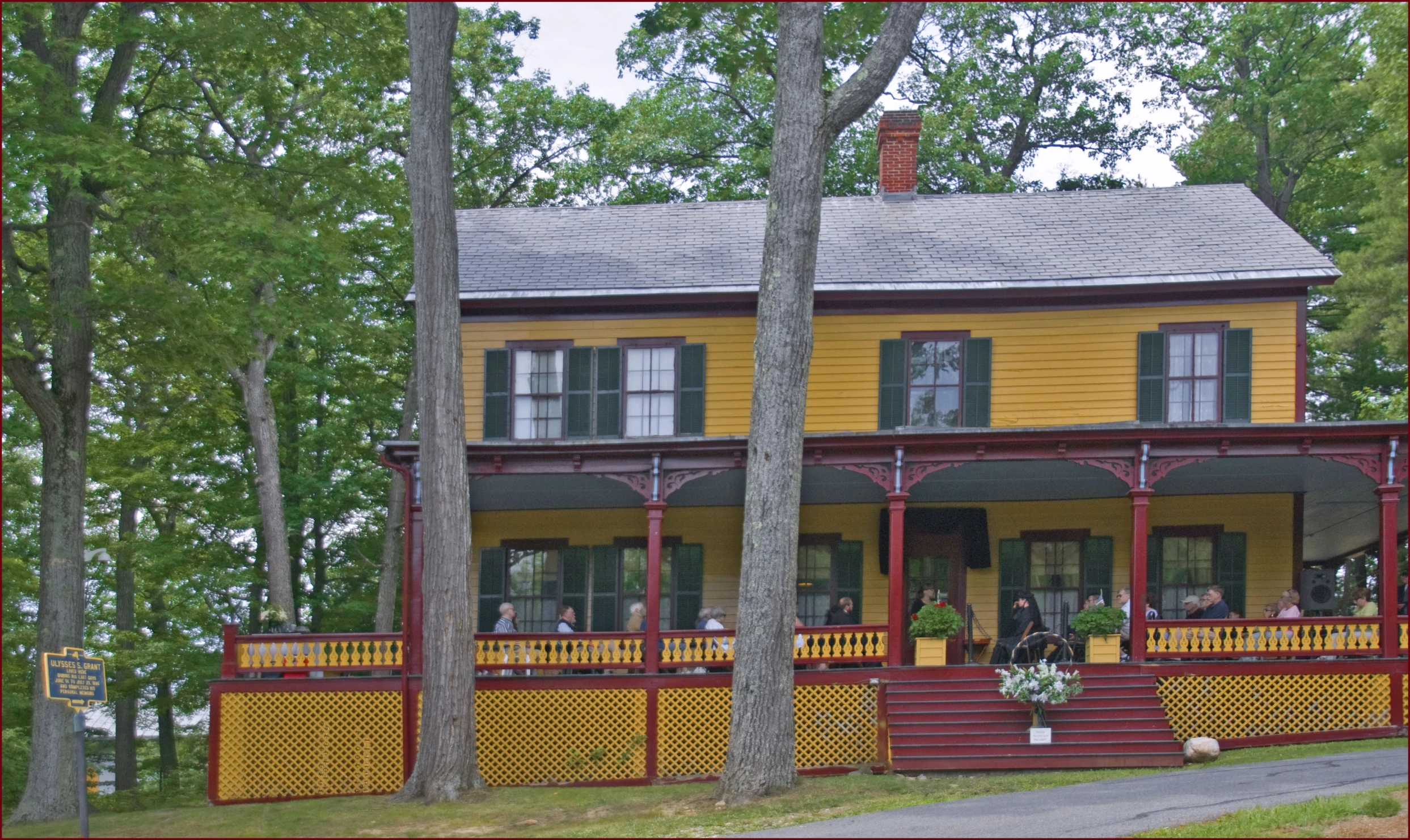 a yellow house sitting on top of a lush green forest