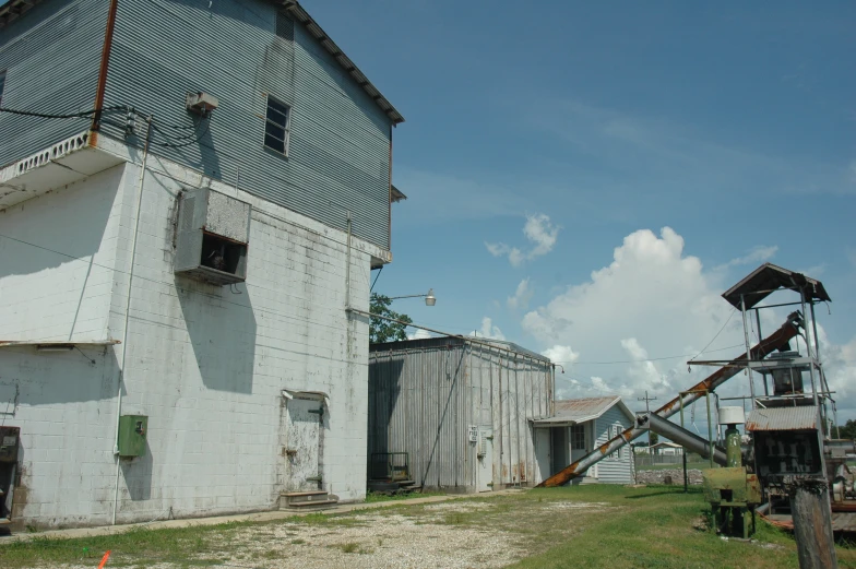 an old metal farm equipment is near an abandoned barn