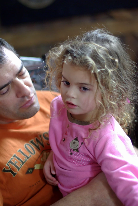 a man sitting next to a small child on a couch