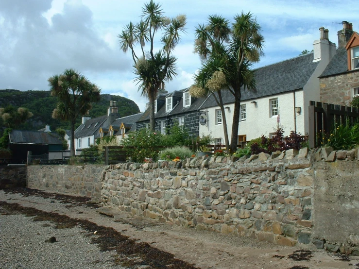 a stone wall and buildings on the shore