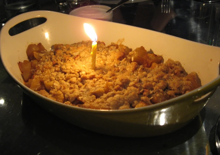 a pan filled with baked food and a candle