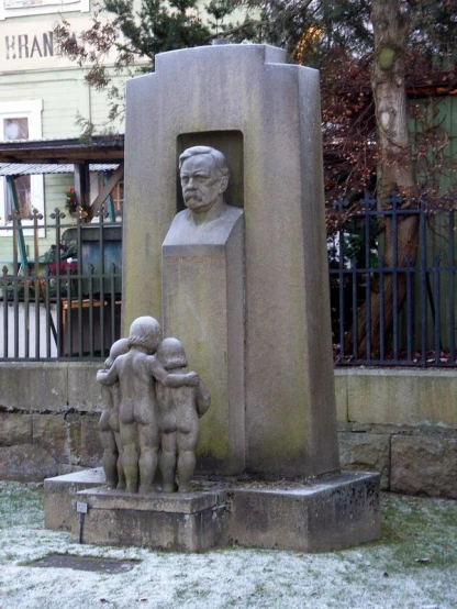 a concrete monument of a man holding two children