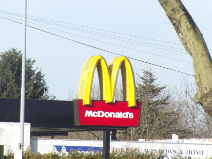 an advertit for a mcdonald's restaurant in front of a sign for the drive - through