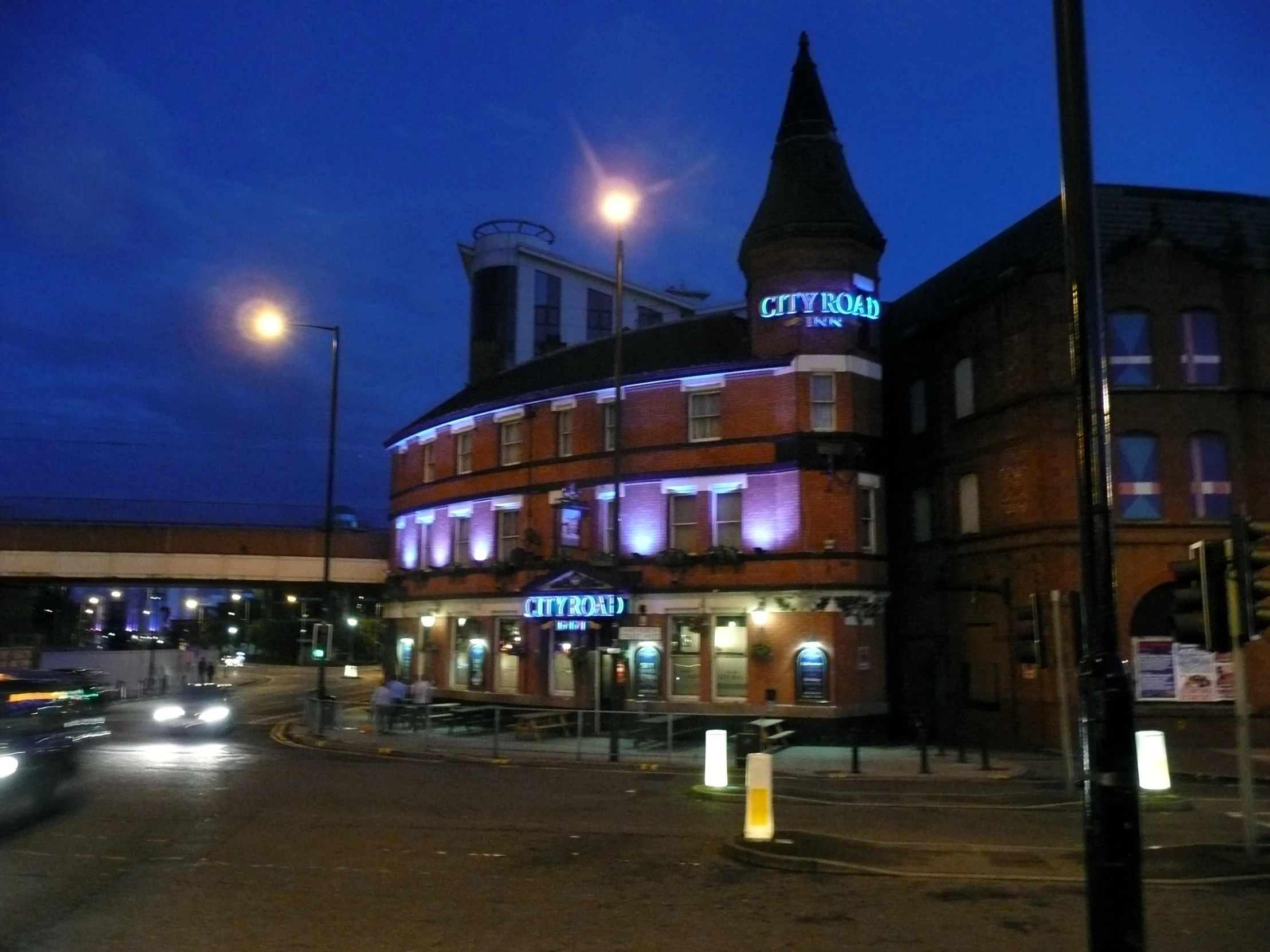 an illuminated sign is lit up on the building in front of it