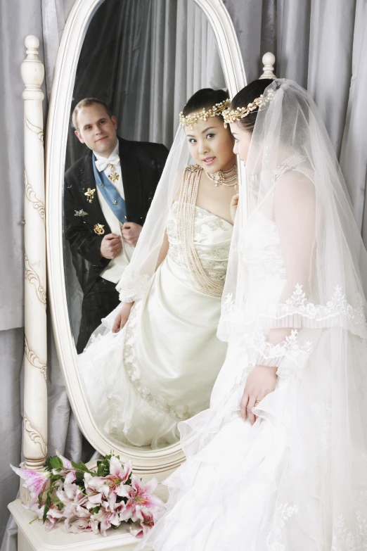 bride and groom standing in front of mirror