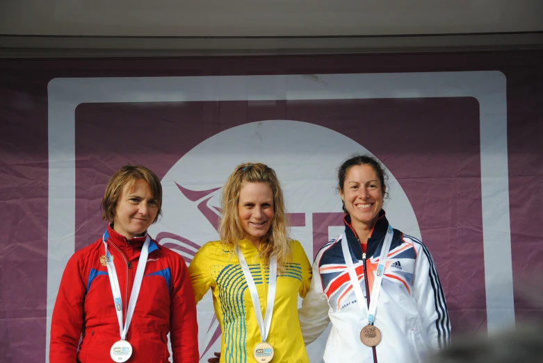 three ladies wearing colorful outfits standing on stage