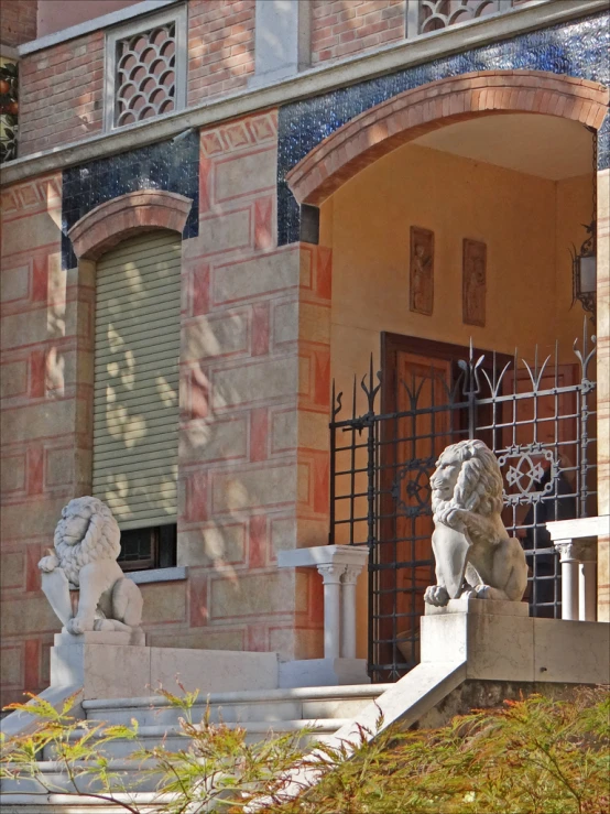 two lions statues standing on the outside steps of a home