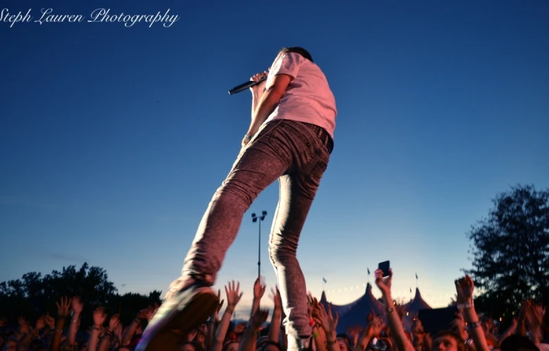 there is a person with their hands raised at the stage