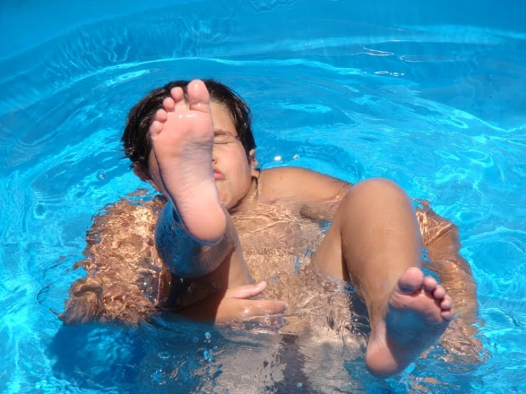 the person is enjoying the nice blue swimming pool