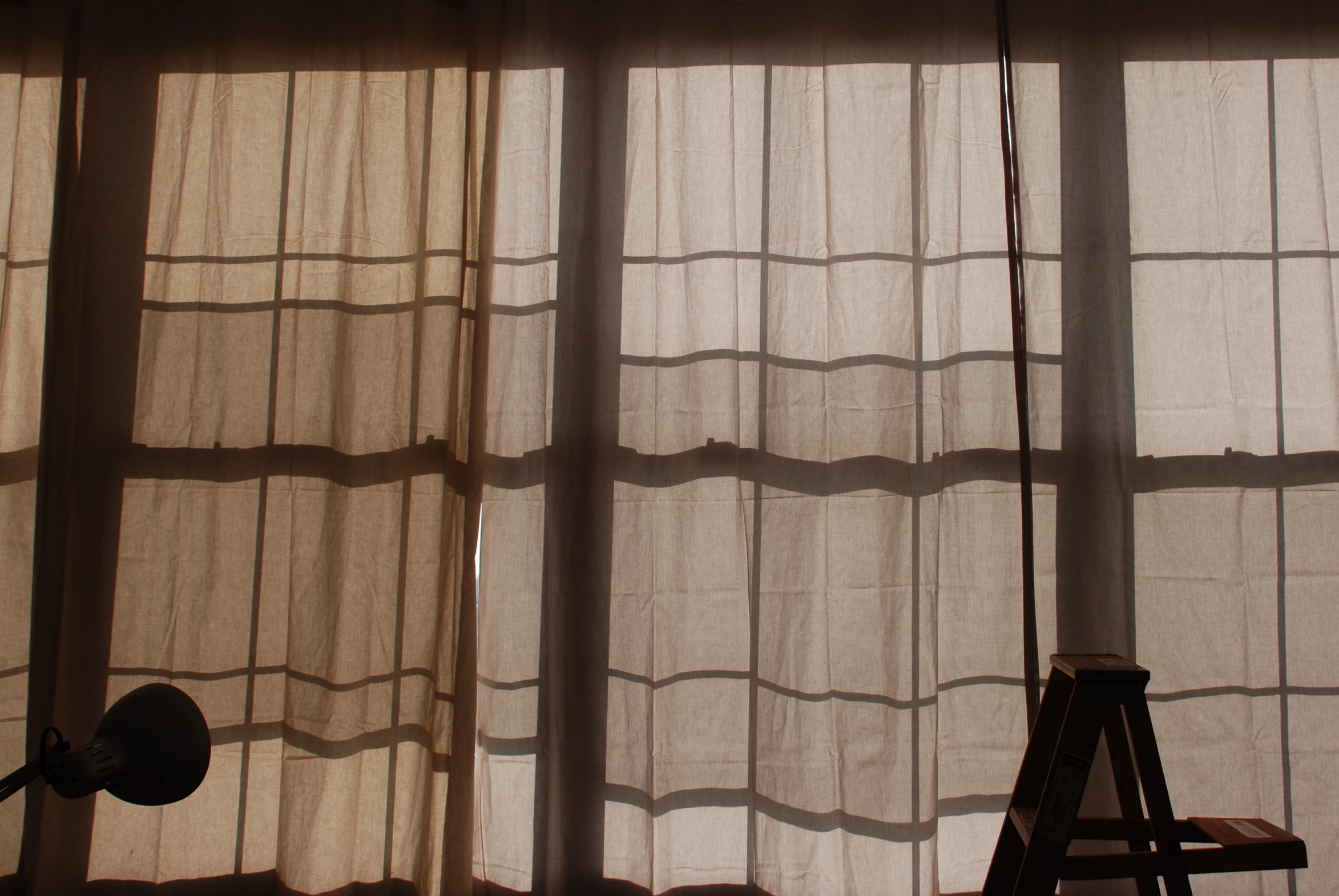 two light streaming through a window onto a ladder