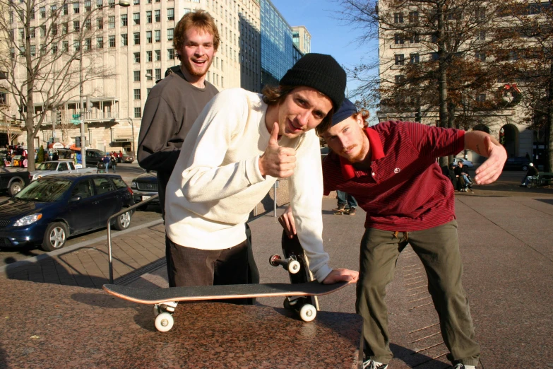 two men who are on the street with a skateboard