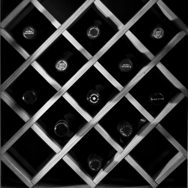 several wine bottles sitting in front of a metal wall