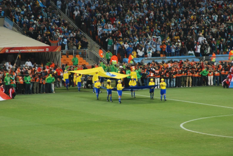 two teams of men with a parachute on top of a soccer field