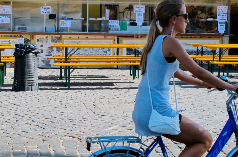 a woman riding on the back of a blue bike