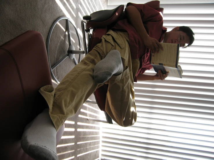 a person sits and reads a book while sitting on a chair