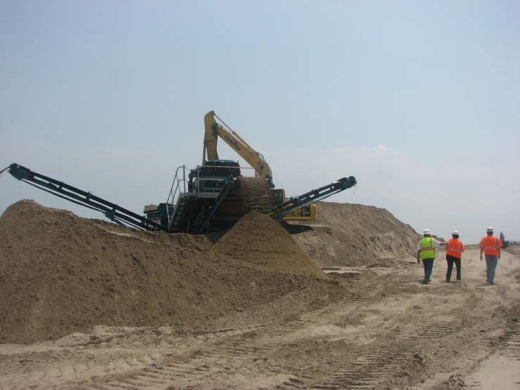 the large sand pile contains piles and cranes