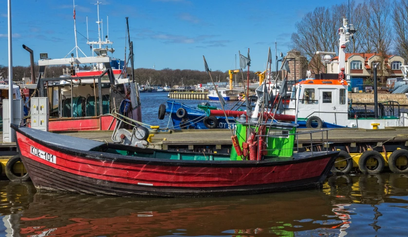 a red fishing boat tied to a dock