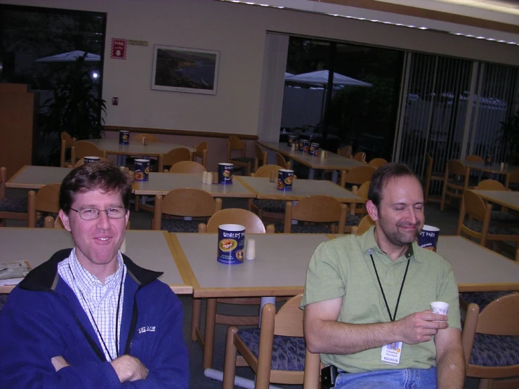 two men in the middle of an indoor cafeteria