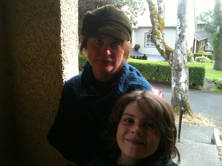 two children are standing outside near a home